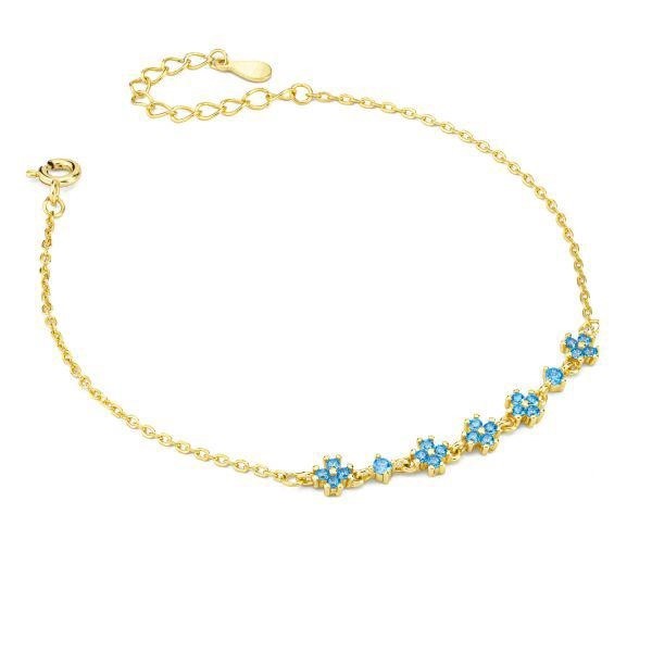 Bracciale dorato con con fiori definiti da zirconi blu